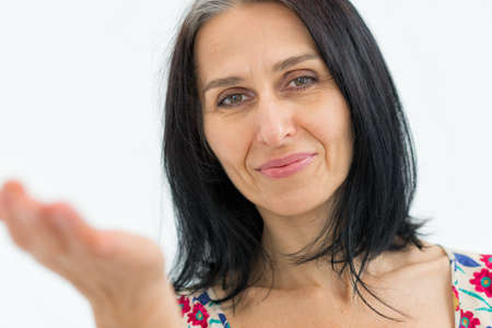 Close-up portrait of middle aged woman starting getting grey-haired wearing dress with flowers on white background, middle age sexy lady, cosmetology conceptの写真素材
