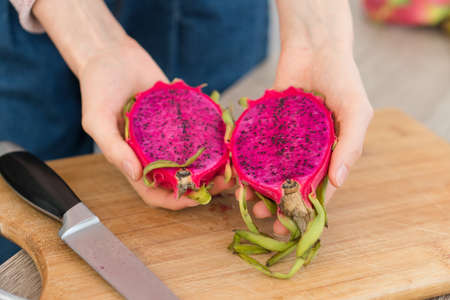 Female hands holding fresh ripe organic dragon fruit or pitaya, pitahaya. Exotic fruits, healthy eating conceptの写真素材