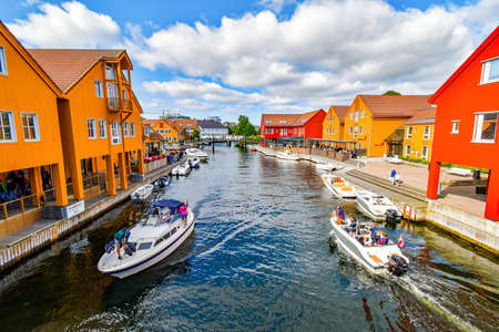 Kristiansand, Norway - July 19, 2017: Motorboats navigate on a canal in the Fiskebrygga district in...