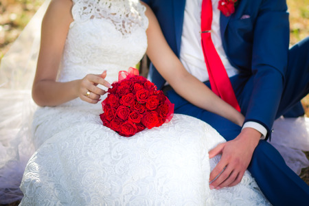 bouquet of red roses on the bride's kneesの写真素材