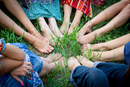 Bare feet of group of young girls in a circle on a green grassの写真素材