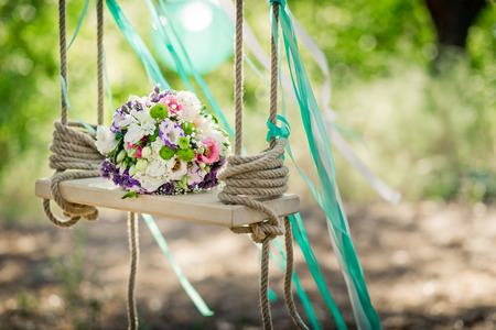 Wedding decor. A bridal bouquet on a decorative swing.Outdoor.の写真素材