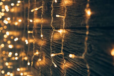 Garland Lights on old grunge wooden board. Christmas and New Year decoration.  Christmas lighting on wooden planksの写真素材