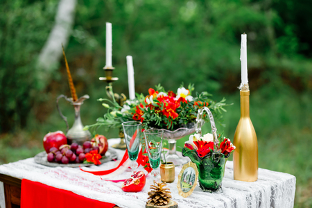 Wedding decor with fruit, flowers, candles  on a table in style of a boho-chic. Decoration of a wedding photoshoot.  Details of a wedding decor.の写真素材