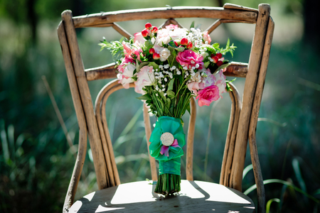 A bridal bouquet with roses, eustoma, berries A bridal bouquet on an ancient chair. Floristic composition.の写真素材