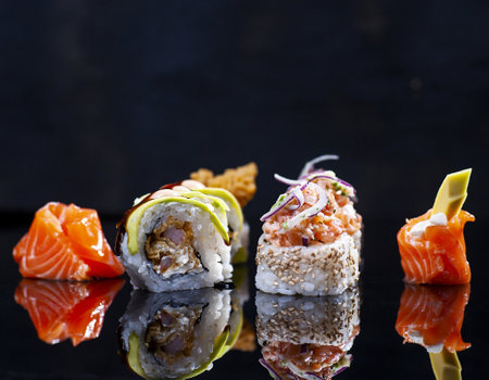 Sushi rolls with salmon, tuna, eel and cucumber on black backgroundの写真素材