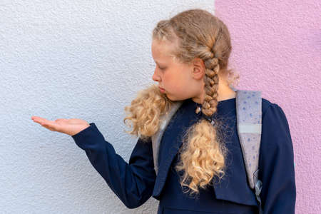 Portrait of a girl on the background. Girl's hand on the background. pupil, learner, scholar....
