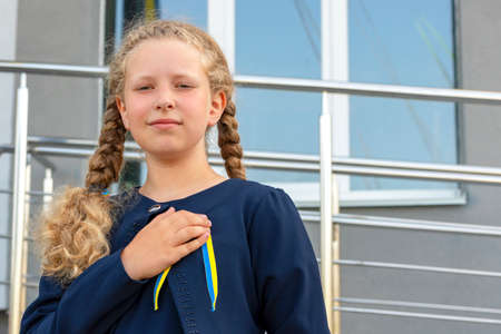 Schoolgirl holds hand on heart! patriot, proud girl, The concept of pride. The concept of pride than...