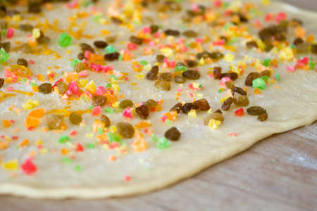 Raisin on the dough. Ingredients for the Easter dough. Dried grapes. Background dough with flour and...