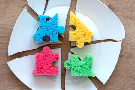 colorful parts on a white shards.Parts of the house on a broken white plate. The concept of the...