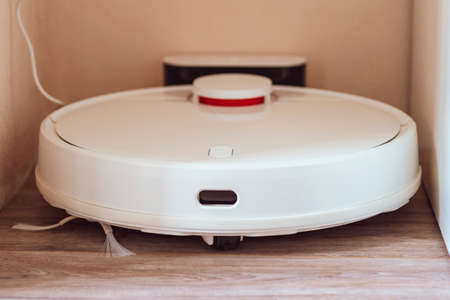 White robot vacuum cleaner. robotic exhauster charging dock station. close-upの写真素材