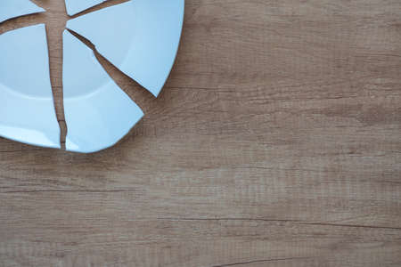 Shards of a Broken Plate on the background. splinters of a shattered Plate. Fragments of a tableware on the floor. splinters and debris of a kitchenware, Copy spaceの写真素材