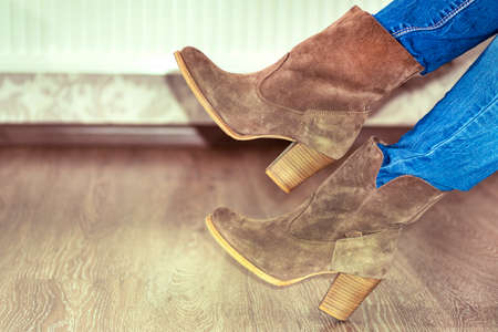Women's suede boots. Women's brown shoes. Shoe fitting.Concept of buying, trying on shoes and...