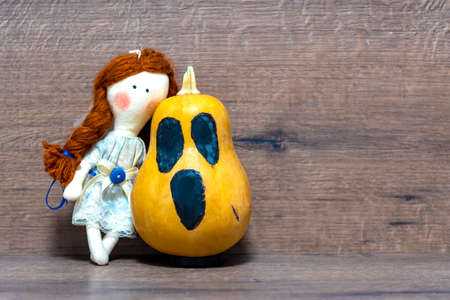 Doll with pumpkin on background. Halloween concept. Decor for halloweenの写真素材