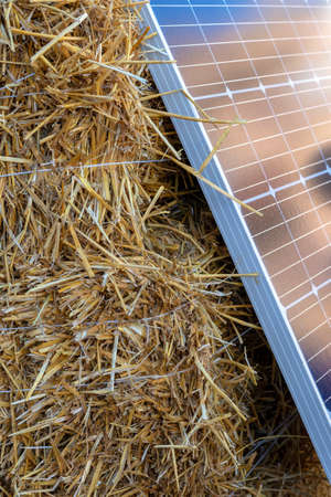 Stacks of straw and solar panels. Concept Alternative fuel source and energy sources. biofuel....