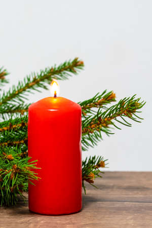 christmas decoration background. Colored candle on a background with spruce branchesの写真素材