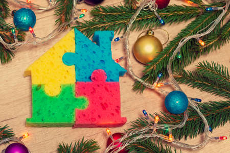 christmas decoration background. Colored house on a background with spruce branches with illuminated decorationの写真素材