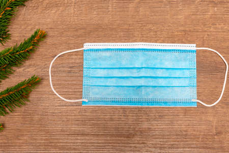 medical mask. Fir tree branches.Christmas background . Christmas quarantine concept.の写真素材