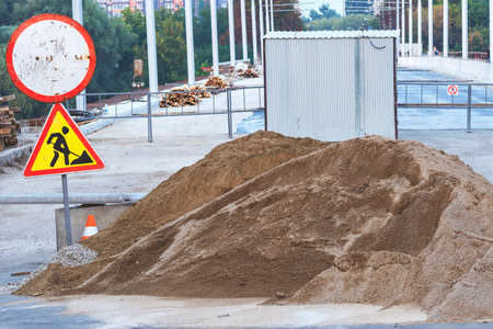Pile of sand.Heap of sand. road signs. Carrying out repair work on the bridge. Repair of the bridge. Equipment for asphalt layingの写真素材