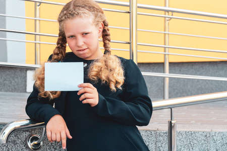 girl holding paper. girl in a uniform. pupil, learner, scholar. schoolgirl.Copy spaceの写真素材