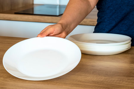 dishes.Kitchen, Dishwasher. The woman puts the plates on the table. Arrangement of dishes.の写真素材