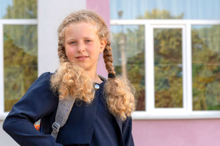 Portrait of a schoolgirl on the background of the school. Concept school days, Back to school. girl...