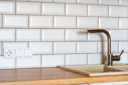 kitchen faucet. Kitchen faucet on the background of kitchen tiles. Modern kitchen, a picture of a faucetの写真素材