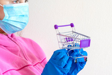 store trolley, face mask, medic hold a shopping cart with medicines. Concept Shortage of medical supplies. Concept Demand, sales growth for medicines and protective equipment.の写真素材