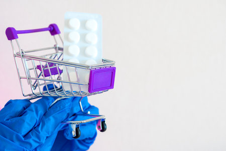 store trolley, Pills. hands in gloves hold a shopping cart with medicines. medical goods. Concept Shortage of medical supplies. Concept Demand, sales growth for medicines and protective equipment.の写真素材