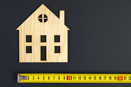 The image of the house on the background. Measurement of the size, tape-measures. The concept of housing, the size of the house. construction conceptの写真素材