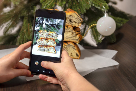 Hands are holding a smartphone. Photographing christmas cake, homemade pie, Home baking concept