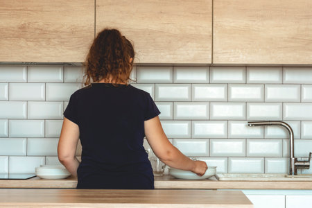 woman stands near table on kitchen at home.woman at home against kitchen background.の写真素材