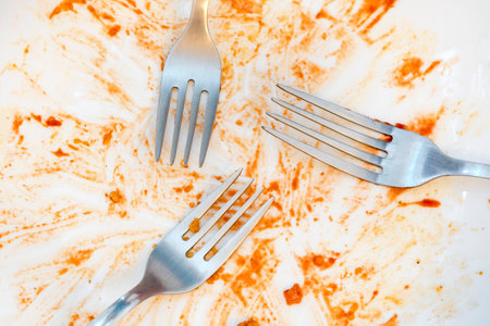dirty plates after eating. Cutlery. forks on a plate. Dirty dishes after eating. End of meal. Good appetite, delicious food and dish conceptの写真素材