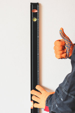 Worker's hands with bubble level. measuring with bubble level.Measurement accuracy concept, modern...