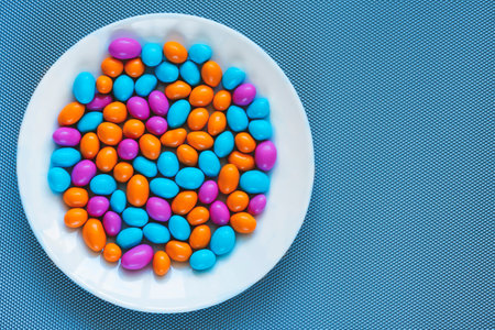 Glazed peanuts of different colors on a plate. Multicolored peanuts. close-up peanuts, kernel, hazelnut, nut, cashew. Copy spaceの写真素材