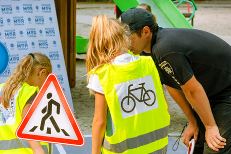 The police officer explains traffic regulations to girls. The cop talks and helps citizens. The...