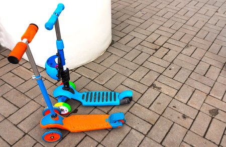 Children's scooters of different colors.The concept of childhood, walking transport for children.