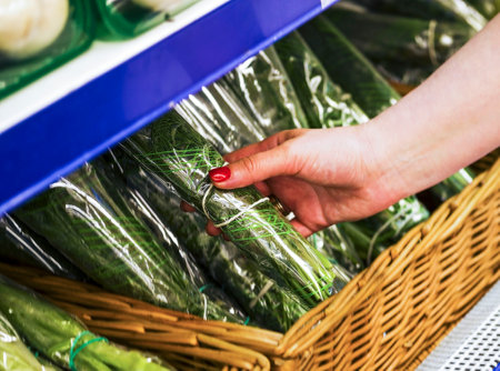 The female hand takes verdure fresh in a supermarket. Purchase of Green fresh, dill in store. Fresh spring verdure at market. close-upの写真素材