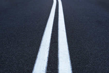 The asphalted road with two continuous white strips. The highway with a white marking. Concept long...