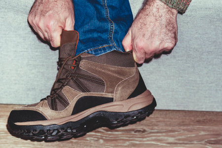 Shoe fitting. A man put on shoes new shoes. Male hands holding a boot. Concept buyers. Shoppers,...