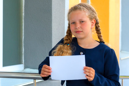 girl holding paper. girl in a uniform. pupil, learner, scholar. schoolgirl.Copy space