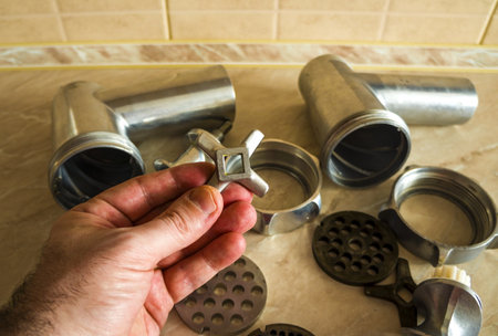 details of a meat grinder, elements of a kitchen device, disassembled meat grinder. mincer in handの写真素材