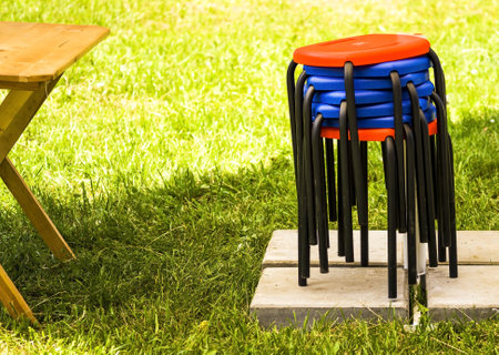 colored stools on the street near a wooden table.Pile of stoolsの写真素材