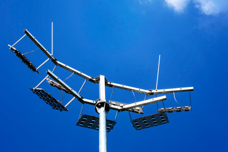 Searchlights. Lighting of the football field. Lighting mast on a background of a blue skyの写真素材