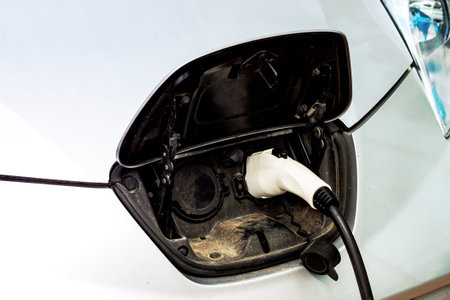 Close up of the power supply plugged into an electric car.Close up image of the power socket of an electric car, charging. Eco-friendly alternative energy conceptの写真素材