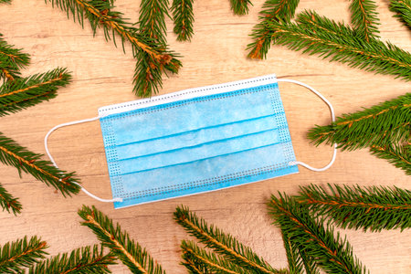 Medical Mask. Fir tree branches.Christmas background. Christmas quarantine concept.の写真素材