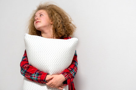Girl hugging with a pillow. Girl holding a pillow. Concept of a good, sound sleep.の写真素材