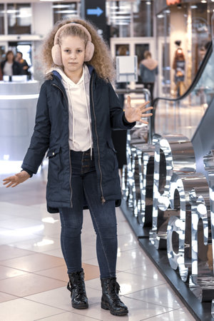 A funny teenager in a jacket. dressed joyful girl with her hair down. Portrait of a cheerful girl late autumn, early springの写真素材