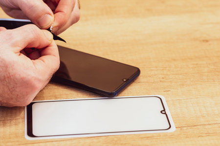 Hands, protective glass, phone. Preparations for gluing protective glass. The concept of protecting...