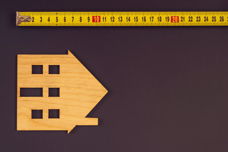 The image of the house on the background. Measurement of the size, tape-measures. The concept of housing, the size of the house. Construction conceptの写真素材